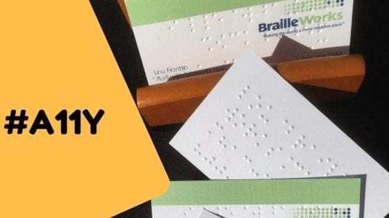 The words "#A11Y" laid over top braille business cards.
