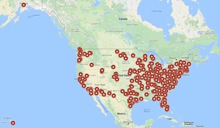 Map of the United States with red colored pins marking different cities around the country.