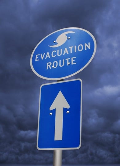 Image showing a blue colored street sign with the words "evacuation route" displayed and an arrow underneath. Image showing a blue colored street sign with the words "evacuation route" displayed and an arrow underneath.