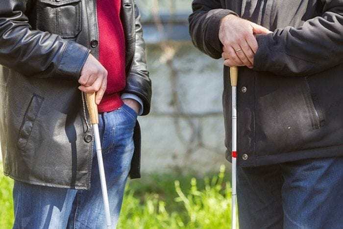 Image showing two men standing next to each other holding white canes. Image showing two men standing next to each other holding white canes.