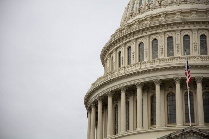 Close up of a government building with an American flag in front.